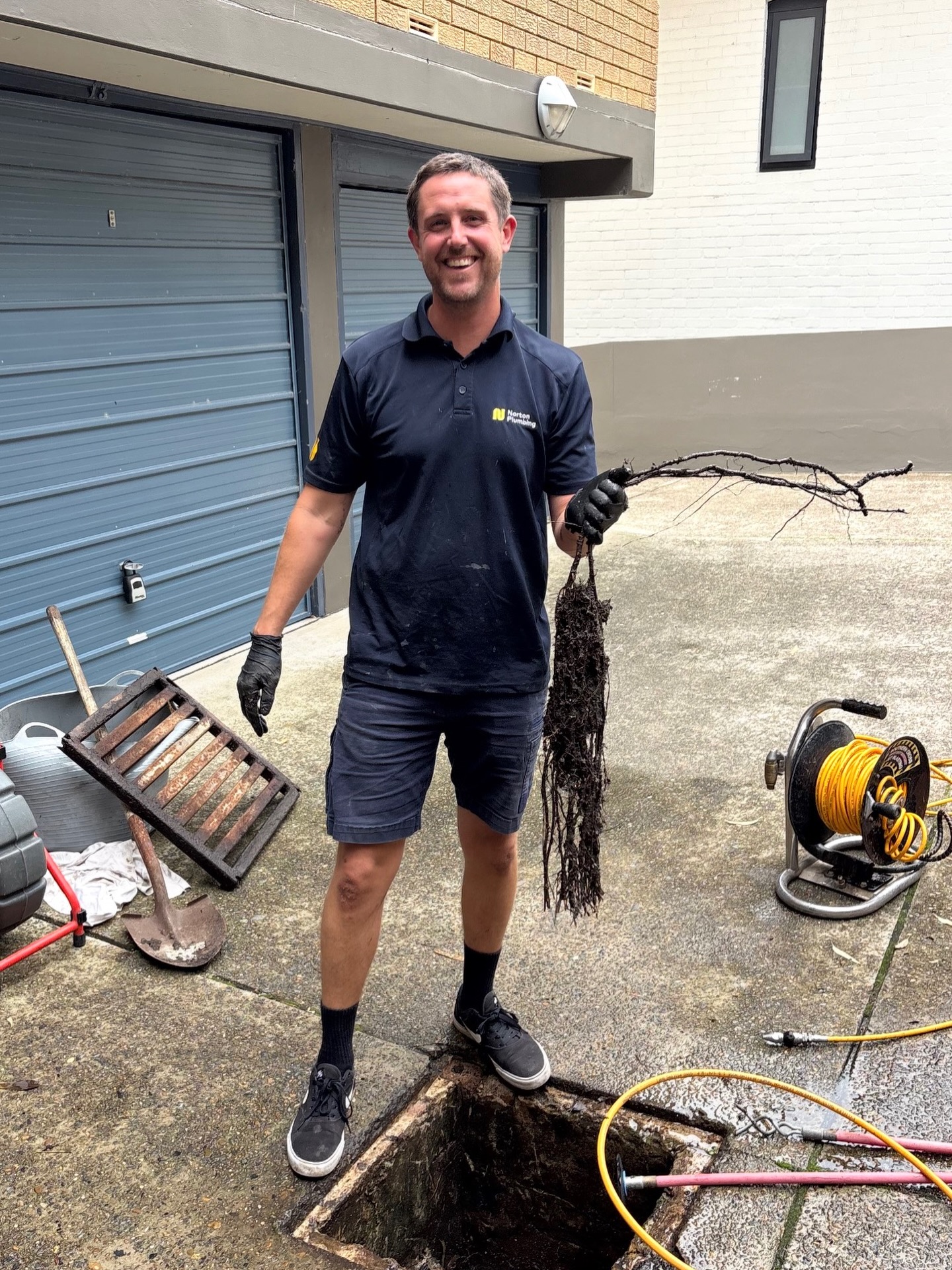 Adam clearing tree roots from a blocked drain